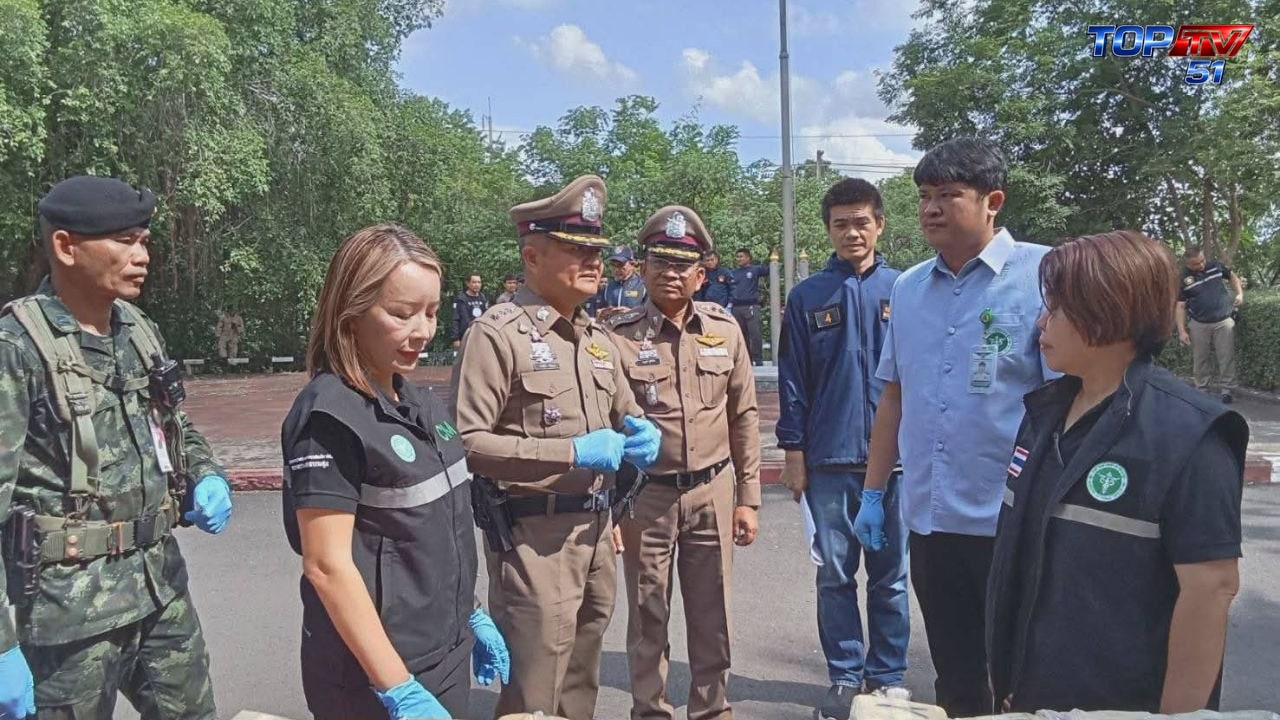 เจ้าหน้าที่ร่วมตรวจสอบห่อของกลางบริเวณโต๊ะแถลงข่าว